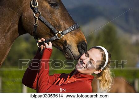 "Young woman cuddling an Austrian Warmblood, bay horse" View Large Photo Image Picture - "Young woman cuddling an Austrian Warmblood, bay horse". Fotosearch