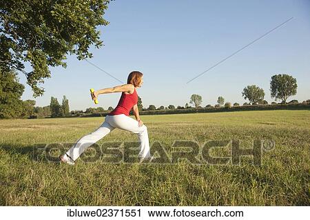 Young woman doing dumbbell exercises in a meadow View Large Photo Image Stock Image - Young woman doing dumbbell exercises in a meadow. Fotosearch