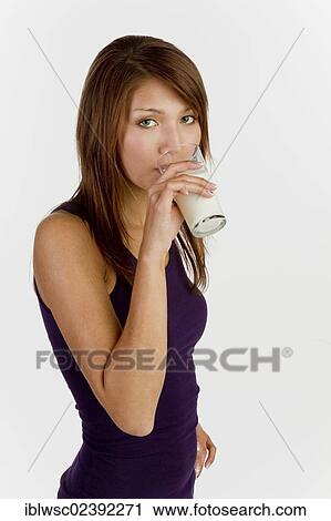 Stock Image - Young woman drinking a glass of milk. Fotosearch