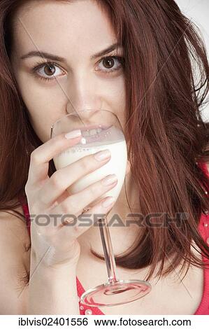 Stock Photograph - Young woman drinking milk from a wine glass. Fotosearch