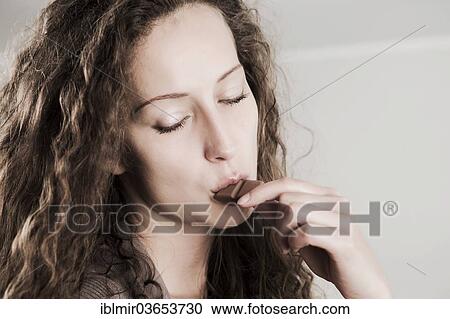 "Young woman eating a bar of chocolate with closed eyes, Germany, Europe" View Large Photo Image Stock Image - "Young woman eating a bar of chocolate with closed eyes, Germany, Europe". Fotosearch