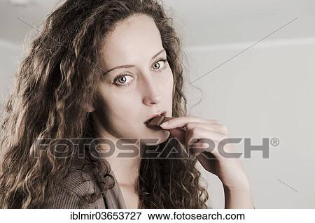 "Young woman eating a bar of chocolate, Germany, Europe" View Large Photo Image Stock Photo - "Young woman eating a bar of chocolate, Germany, Europe". Fotosearch