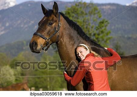 "Young woman embracing an Austrian Warmblood, bay horse" View Large Photo Image Stock Photo - "Young woman embracing an Austrian Warmblood, bay horse". Fotosearch