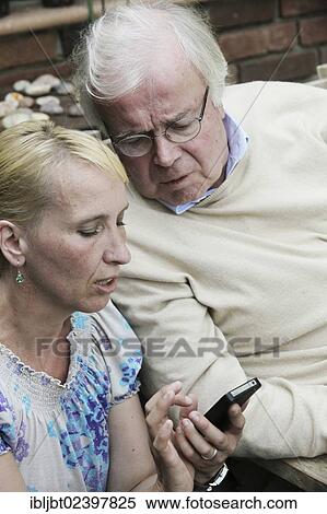 Young woman explaining a smartphone to an elderly man View Large Photo Image Stock Photography - Young woman explaining a smartphone to an elderly man. Fotosearch