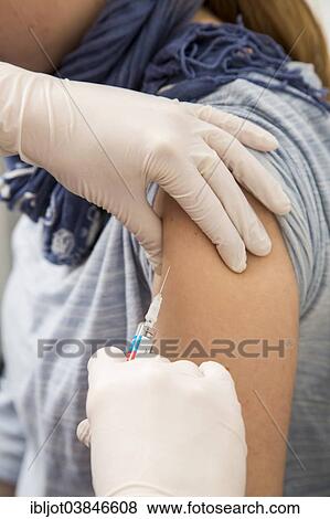 Stock Photo - "Young woman getting a flu shot, influenza vaccine, Germany, Europe". Fotosearch