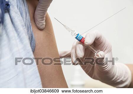 "Young woman getting a flu shot, influenza vaccine, Germany, Europe" View Large Photo Image Stock Photo - "Young woman getting a flu shot, influenza vaccine, Germany, Europe". Fotosearch