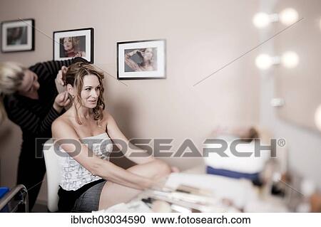 Stock Image - "Young woman having her hair styled by a hairdresser, Austria, Europe". Fotosearch