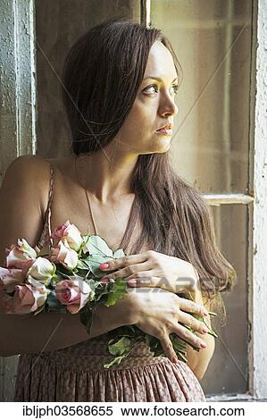 Stock Photography - "Young woman holding a bunch of roses, Germany, Europe". Fotosearch