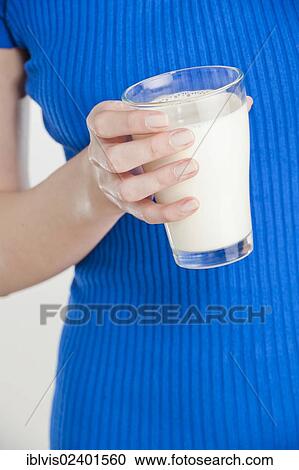 Young woman holding a glass of milk View Large Photo Image Stock Image - Young woman holding a glass of milk. Fotosearch