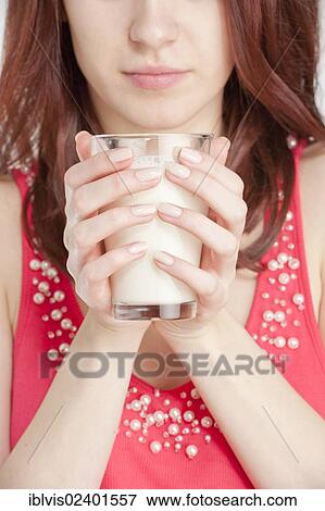 Stock Photo - Young woman holding a glass of milk. Fotosearch