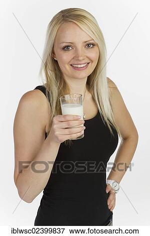 Young woman holding a glass of milk View Large Photo Image Stock Photo - Young woman holding a glass of milk. Fotosearch