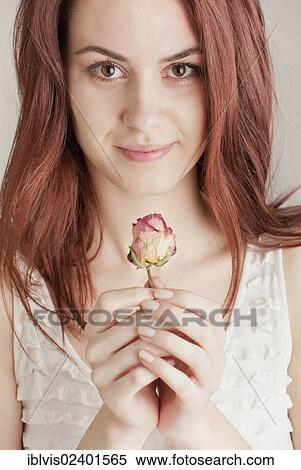 Young woman holding a rose View Large Photo Image Stock Photography - Young woman holding a rose. Fotosearch