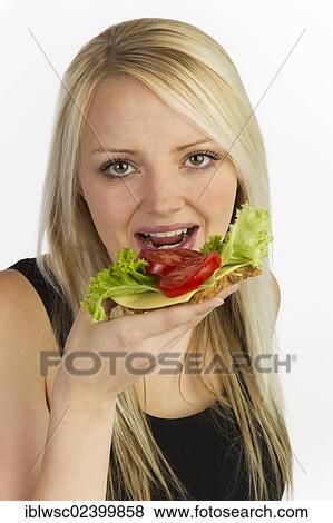 "Young woman holding a slice of bread with grains, topped with cheese and tomato" View Large Photo Image Stock Photo - "Young woman holding a slice of bread with grains, topped with cheese and tomato". Fotosearch