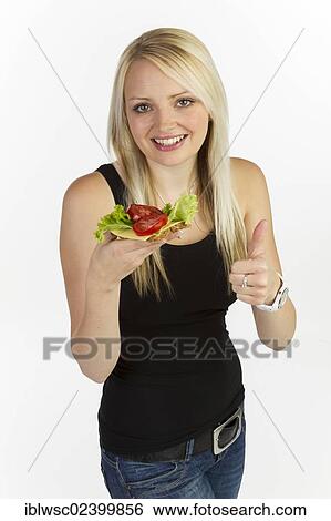 "Young woman holding a slice of bread with grains, topped with cheese and tomato" View Large Photo Image Stock Photograph - "Young woman holding a slice of bread with grains, topped with cheese and tomato". Fotosearch