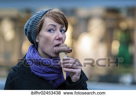 Stock Photo - "Young woman holding an ice cream cone with chocolate ice cream, Grevenbroich, North Rhine-Westphalia, Germany, Europe". Fotosearch