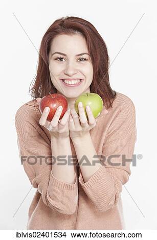 Picture - Young woman holding two apples. Fotosearch