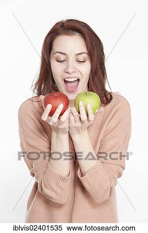 Stock Photography - Young woman holding two apples. Fotosearch