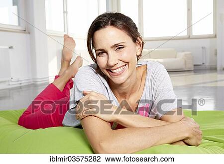 "Young woman in casual clothes lying on bean bag in a loft, Germany, Europe" View Large Photo Image Stock Image - "Young woman in casual clothes lying on bean bag in a loft, Germany, Europe". Fotosearch