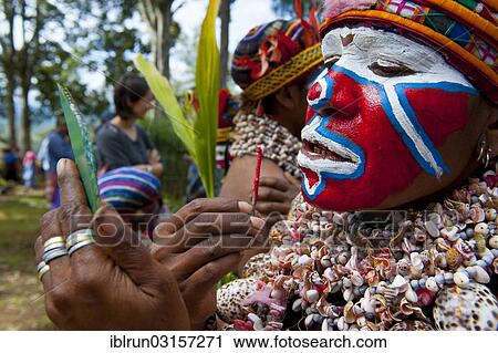 "Young woman is applying face paint for the traditional Sing Sing gathering in the highlands, Paya, Papua New Guinea, Oceania" View Large Photo Image Stock Image - "Young woman is applying face paint for the traditional Sing Sing gathering in the highlands, Paya, Papua New Guinea, Oceania". Fotosearch