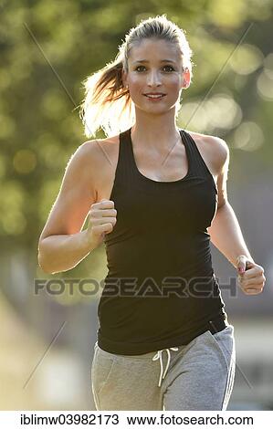 "Young woman jogging, Germany, Europe" View Large Photo Image Stock Image - "Young woman jogging, Germany, Europe". Fotosearch