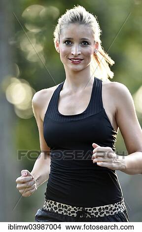 Picture - "Young woman jogging in summer, Germany, Europe". Fotosearch