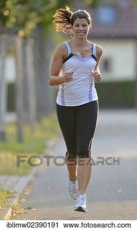 Stock Image - "Young woman jogging, Stuttgart, Baden-Wuerttemberg, Germany, Europe, PublicGround, Europe". Fotosearch