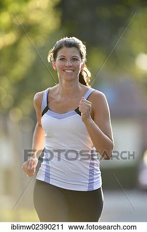 Stock Image - "Young woman jogging, Stuttgart, Baden-Wuerttemberg, Germany, Europe, PublicGround, Europe". Fotosearch