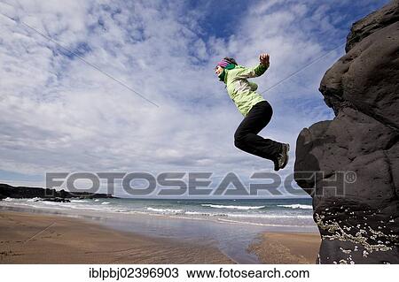 "Young woman jumping a cliff on the coast, Iceland, Europe" View Large Photo Image Stock Image - "Young woman jumping a cliff on the coast, Iceland, Europe". Fotosearch