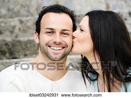 "Young woman kissing a young man on the cheek, Austria, Europe" View Large Photo Image Stock Image - "Young woman kissing a young man on the cheek, Austria, Europe". Fotosearch