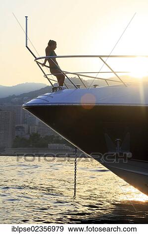 "Young woman leaning against the railing of the bow of a motor yacht in the evening with backlighting, Principality of Monaco, Cote d'Azur, Mediterranean, Europe" View Large Photo Image Stock Photo - "Young woman leaning against the railing of the bow of a motor yacht in the evening with backlighting, Principality of Monaco, Cote d'Azur, Mediterranean, Europe". Fotosearch