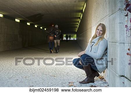 Young woman leaning against the wall of an underpass View Large Photo Image Stock Photo - Young woman leaning against the wall of an underpass. Fotosearch