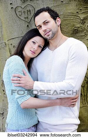 "Young woman leaning on the shoulder of a young man in front of a tree with a carved heart, Austria, Europe" View Large Photo Image Picture - "Young woman leaning on the shoulder of a young man in front of a tree with a carved heart, Austria, Europe". Fotosearch