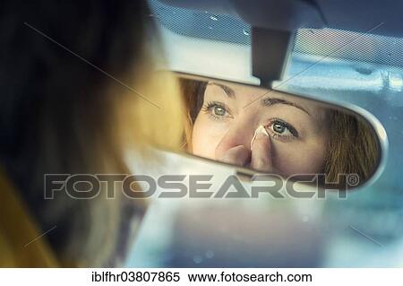 "Young woman looking at herself in a rear-view mirror whilst dabbing away tears, Germany, Europe" View Large Photo Image Stock Photography - "Young woman looking at herself in a rear-view mirror whilst dabbing away tears, Germany, Europe". Fotosearch