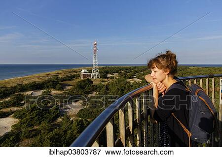 "Young woman looking out from the Leuchtturm Darsser Ort lighthouse, Darss, Western Pomerania Lagoon Area National Park, Mecklenburg-Vorpommern, Germany, Europe" View Large Photo Image Stock Photo - "Young woman looking out from the Leuchtturm Darsser Ort lighthouse, Darss, Western Pomerania Lagoon Area National Park, Mecklenburg-Vorpommern, Germany, Europe". Fotosearch
