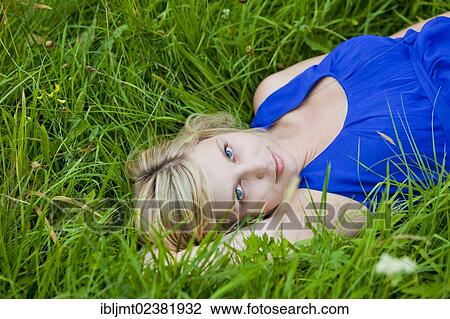Young woman lying in the grass View Large Photo Image Stock Image - Young woman lying in the grass. Fotosearch
