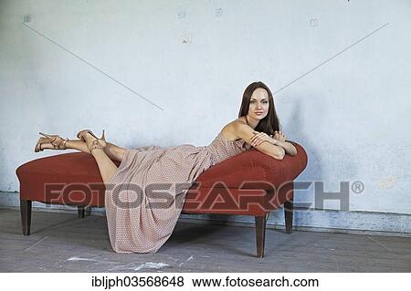 "Young woman lying on a chaise longue in a room in need of redecoration, Germany, Europe" View Large Photo Image Stock Photo - "Young woman lying on a chaise longue in a room in need of redecoration, Germany, Europe". Fotosearch