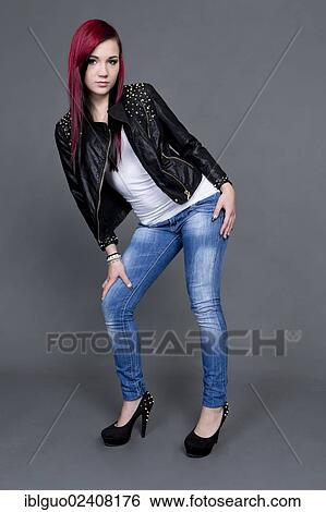 Stock Photograph - "Young woman posing in a leather jacket, jeans and high heels". Fotosearch