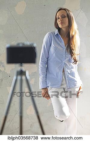 Stock Photo - "Young woman posing in front of a vintage camera, Germany, Europe". Fotosearch