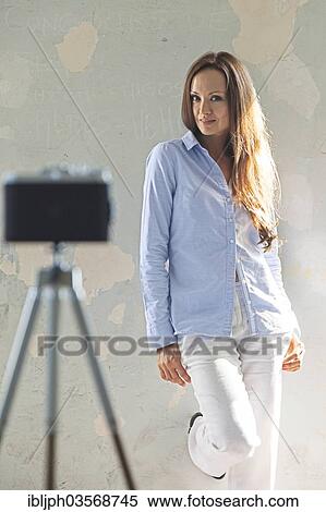 Stock Photography - "Young woman posing in front of a vintage camera, Germany, Europe". Fotosearch