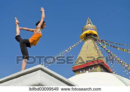 "Young woman practicing yoga at Boudnanath stupa, showing the Natarajasana pose, or Lord Shiva's pose, Kathmandu Valley, Kathmandu, Kathmandu District, Bagmati Zone, Nepal, Asia" View Large Photo Image Stock Photo - "Young woman practicing yoga at Boudnanath stupa, showing the Natarajasana pose, or Lord Shiva's pose, Kathmandu Valley, Kathmandu, Kathmandu District, Bagmati Zone, Nepal, Asia". Fotosearch