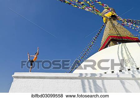 "Young woman practicing yoga at Boudnanath stupa, showing the Natarajasana pose, or Lord Shiva's pose, Kathmandu Valley, Kathmandu, Kathmandu District, Bagmati Zone, Nepal, Asia" View Large Photo Image Stock Photo - "Young woman practicing yoga at Boudnanath stupa, showing the Natarajasana pose, or Lord Shiva's pose, Kathmandu Valley, Kathmandu, Kathmandu District, Bagmati Zone, Nepal, Asia". Fotosearch