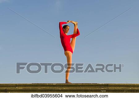"Young woman practising Hatha yoga, outdoors, showing the pose Utthita Hasta Pandangusthasana, raised hand to big toe pose" View Large Photo Image Picture - "Young woman practising Hatha yoga, outdoors, showing the pose Utthita Hasta Pandangusthasana, raised hand to big toe pose". Fotosearch