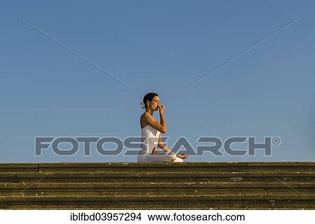 "Young woman practising Hatha yoga, outdoors, showing the pose Anuloma viloma, Nadi shodhana pranayama, Alternate nostril breathing" View Large Photo Image Picture - "Young woman practising Hatha yoga, outdoors, showing the pose Anuloma viloma, Nadi shodhana pranayama, Alternate nostril breathing". Fotosearch