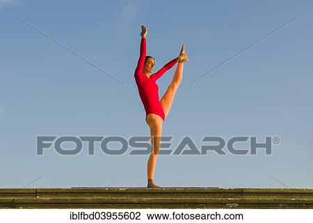 "Young woman practising Hatha yoga, outdoors, showing the pose Anjaneyasana, raised hand to foot pose" View Large Photo Image Stock Image - "Young woman practising Hatha yoga, outdoors, showing the pose Anjaneyasana, raised hand to foot pose". Fotosearch