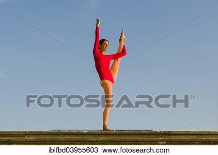 "Young woman practising Hatha yoga, outdoors, showing the pose Anjaneyasana, raised hand to foot pose" View Large Photo Image Stock Image - "Young woman practising Hatha yoga, outdoors, showing the pose Anjaneyasana, raised hand to foot pose". Fotosearch