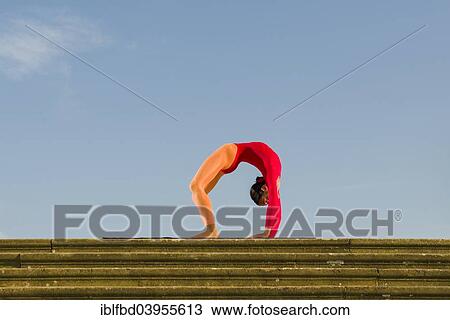 "Young woman practising Hatha yoga, outdoors, showing the pose Chakrasana, Urdhva Dhanurasana, Wheel pose" View Large Photo Image Stock Image - "Young woman practising Hatha yoga, outdoors, showing the pose Chakrasana, Urdhva Dhanurasana, Wheel pose". Fotosearch