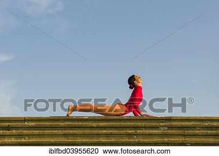 "Young woman practising Hatha yoga, outdoors, showing the pose Bhujangasana, Cobra pose" View Large Photo Image Stock Image - "Young woman practising Hatha yoga, outdoors, showing the pose Bhujangasana, Cobra pose". Fotosearch