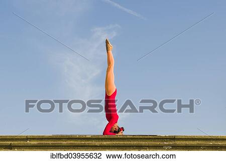 "Young woman practising Hatha yoga, outdoors, showing the pose Sirshasana, Head stand" View Large Photo Image Stock Image - "Young woman practising Hatha yoga, outdoors, showing the pose Sirshasana, Head stand". Fotosearch
