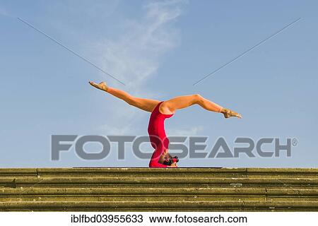 "Young woman practising Hatha yoga, outdoors, showing the pose Sirshasana, Head stand" View Large Photo Image Stock Image - "Young woman practising Hatha yoga, outdoors, showing the pose Sirshasana, Head stand". Fotosearch