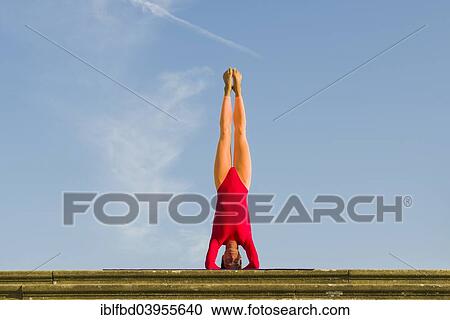 "Young woman practising Hatha yoga, outdoors, showing the pose Sirshasana, Head stand" View Large Photo Image Stock Image - "Young woman practising Hatha yoga, outdoors, showing the pose Sirshasana, Head stand". Fotosearch